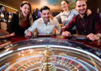Excited group of friends playing roulette in casino